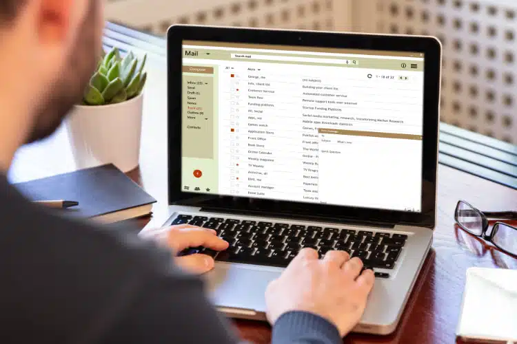 Marketing employee looking on his email using a laptop.