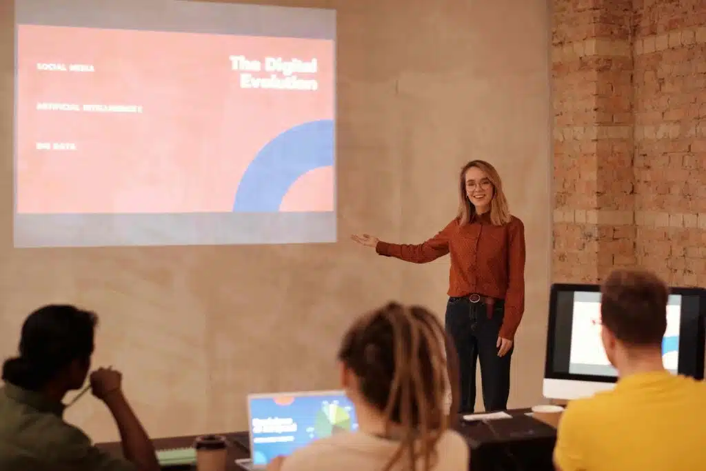 A woman stands before a group, presenting insights on AI Marketing